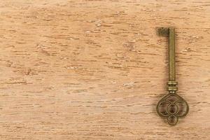 Antique key on wooden background photo