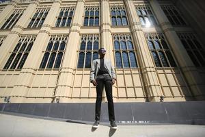 hombre afroamericano divirtiéndose caminando en el centro de la ciudad - joven feliz disfrutando del tiempo una puesta de sol al aire libre - estilo de vida de generación milenaria y concepto de actitud positiva de la gente foto