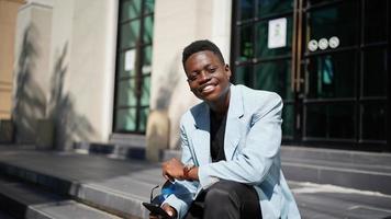 hombre afroamericano divirtiéndose caminando en el centro de la ciudad - joven feliz disfrutando del tiempo una puesta de sol al aire libre - estilo de vida de generación milenaria y concepto de actitud positiva de la gente foto