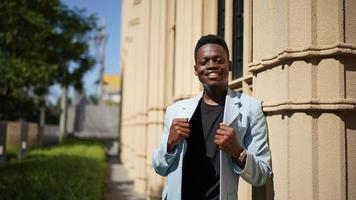 hombre afroamericano divirtiéndose caminando en el centro de la ciudad - joven feliz disfrutando del tiempo una puesta de sol al aire libre - estilo de vida de generación milenaria y concepto de actitud positiva de la gente foto