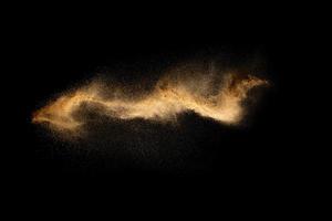 Abstract motion blurred brown sand background.Sandy explosion isolated on over dark background. photo