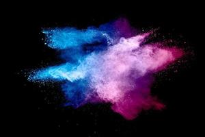 Abstract blue pink powder explosion on white background. Closeup of blue pink dust particles splash isolated. photo