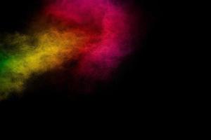 Explosion of colorful pigment powder on black background.Vibrant color dust particles textured background. photo