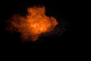 Orange powder splattered on white background.Abstract dust cloud  backdrop. photo