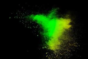 Abstract splash of green colored powder on black background.Green powder explosion. photo