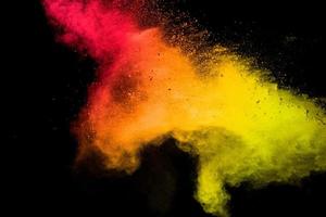 Red yellow powder explosion cloud on black background. photo