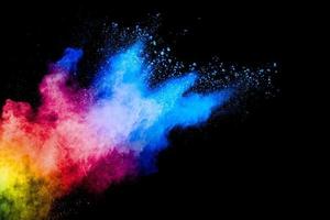 Colorful powder explosion on black background. Abstract pastel color dust particles splash. photo