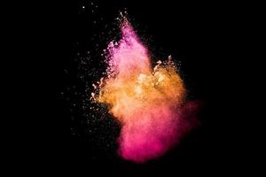 Pink orange dust particles splash on white background.Colorful powder splash. photo