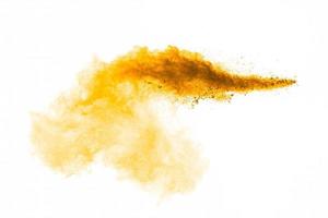 Orange powder splattered on white background.Abstract design of color dust cloud. photo