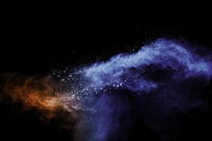 Blue orange color powder explosion on black background. photo