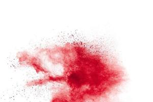 Red powder explosion on white background. Freeze motion of red dust particles splash. photo