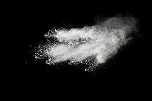 White powder explosion cloud against black background.White dust particles splash. photo