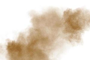 nube de explosión de polvo de color marrón sobre fondo blanco. salpicaduras de polvo marrón sobre fondo. foto