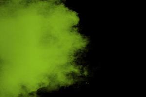 A splatter of green colored powder on black background. photo