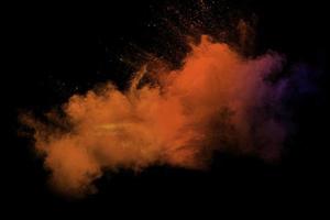 movimiento borroso abstracto de partículas de polvo de colores sobre fondo negro. textura de superposición de polvo de color de tono caliente abstracto. foto