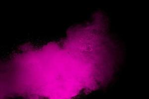 explosión de polvo rosa aislado sobre fondo negro. foto
