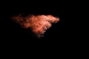 Orange color powder explosion on black background. photo