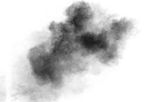 Black particles splattered on white background. Black powder dust splashing. photo