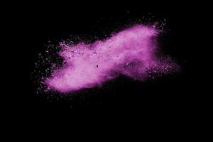 Pink dust particles splash on black background.Pink powder splash. photo