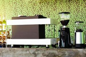 la cafetería con máquina de hacer y granos de café tostados en molinillo. foto