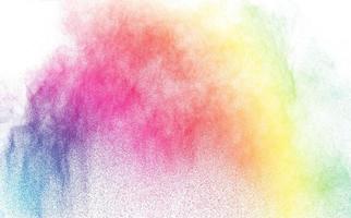 polvo multicolor abstracto salpicado sobre fondo blanco, movimiento congelado de explosión de polvo de color foto