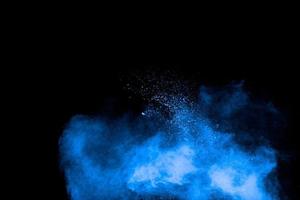 Blue powder explosion cloud on black background.Launched blue dust particles splash on background. photo