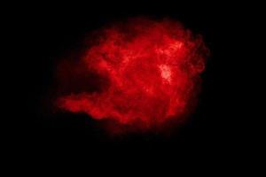 Red  color powder explosion on black background. photo