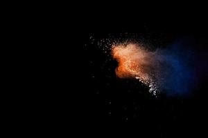 Orange blue color powder explosion on black background. photo