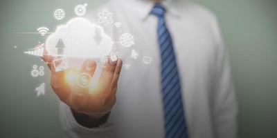 Businessman holding cloud computing online and business icon for providing access to information and data global connection, innovation and technology. Technology internet online, business concept. photo