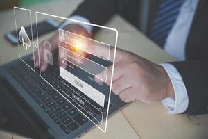 Businessman input password login uses a laptop computer. Preventing identity cybersecurity from online internet hackers. Login to access personal information. Secure Internet access, cybersecurity. photo