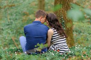 Young beautiful couple in love in the forest. A couple is hugging near a ravine among the trees. Free space.