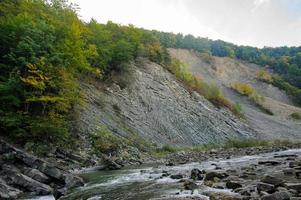 Collision layers of the mainland plates that formed the mountains. Near the river flows photo