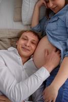 The future father listens as his child beats in the belly of his pregnant wife. photo