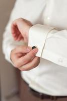 Men's hands adjust cufflinks on the sleeves. photo