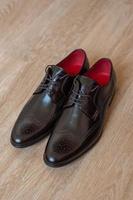 Brown shoes for men on a wooden background. photo