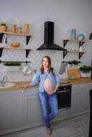 mujer embarazada de pie en su cocina