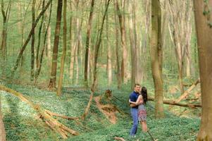 Young beautiful couple in love in the forest. A couple is hugging near a ravine among the trees. Free space. photo