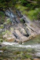 capas de colisión de las placas continentales que formaron las montañas. cerca del río fluye foto