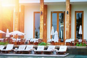 Beach front of hotel in day time and crouch and umbrella photo