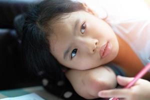 Girl lie down for writing notebook on floor photo