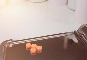 four orange medical tablets on half counting drug tray for drugstore photo