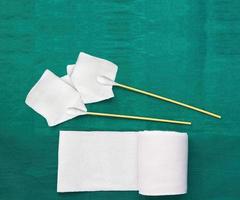 tools include swabs,roll gauze and blood gauze on green surgical dress  for clean wound photo