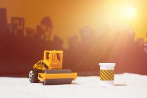 Road roller toy with pipe blocker on blur city background photo