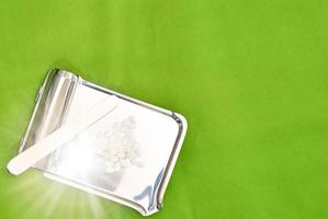 pharmacy tray with white pills on green medical background photo