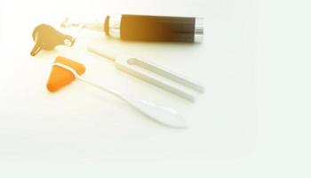 Tuning fork and Blur Otoscope and hammer jerk on white floor ,top view with copy space photo