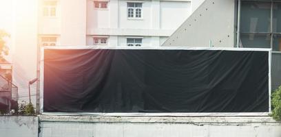 Black mock up billboard on fence on blur city background photo