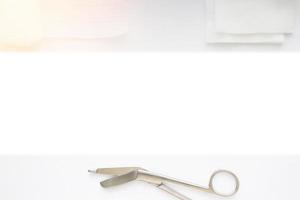 Gauzes, scissors and roll gauze on white background with green strip copy space photo