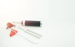 Tuning fork and Blur Otoscope and hammer jerk on white floor ,top view with copy space photo