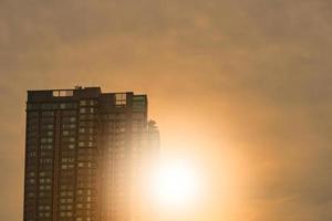 edificio alto en el fondo del cielo del amanecer con luz solar foto