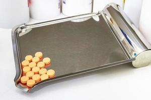 orange medical tablets on counting drug tray photo